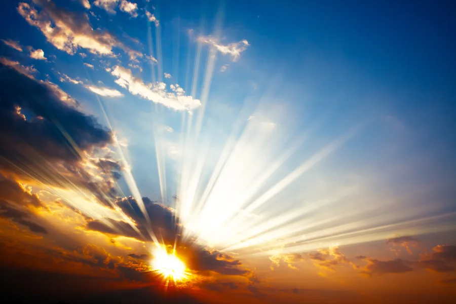 Sunlight breaking through clouds at sunrise